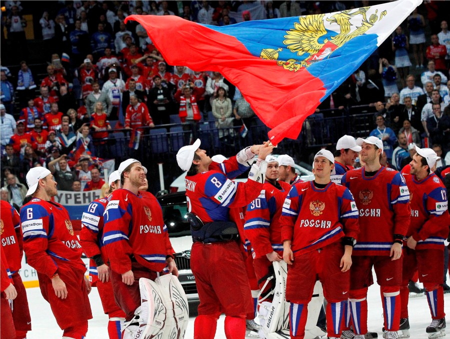 Russia's Alexander Ovechkin (C) holds a national flag as he celebrates with his teammates winning their 2012 IIHF men's ice hockey World Championship final game against Slovakia in Helsinki May 20, 2012. REUTERS/Petr Josek (FINLAND - Tags: SPORT ICE HOCKEY)