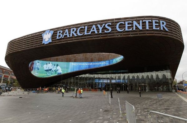 FILE - This Sept. 20, 2012 file photo shows workers sweeping the plaza in front of the main entrance to the Barclays Center in the Brooklyn borough of New York. Consider Madison Square Garden and The Rock on watch. There's a new kid in town, folks, a state-of-the-art arena in Brooklyn that is gobbling up acts at an alarming rate. (AP Photo/Kathy Willens, File)