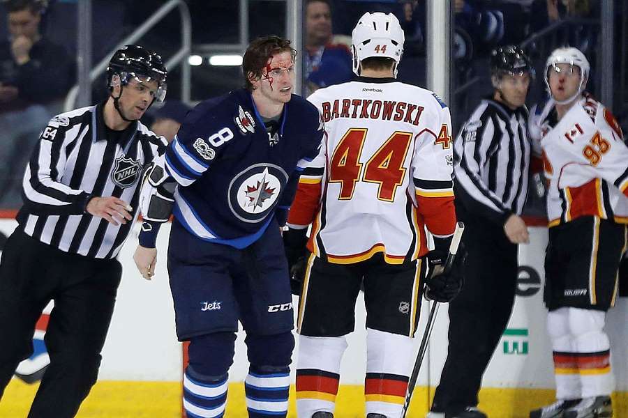 Winnipeg Jets' Jacob Trouba (8) is escorted off the ice after a fight with Calgary Flames' Sam Bennett (93) during second period NHL action in Winnipeg on Saturday, March 11, 2017. THE CANADIAN PRESS/John Woods